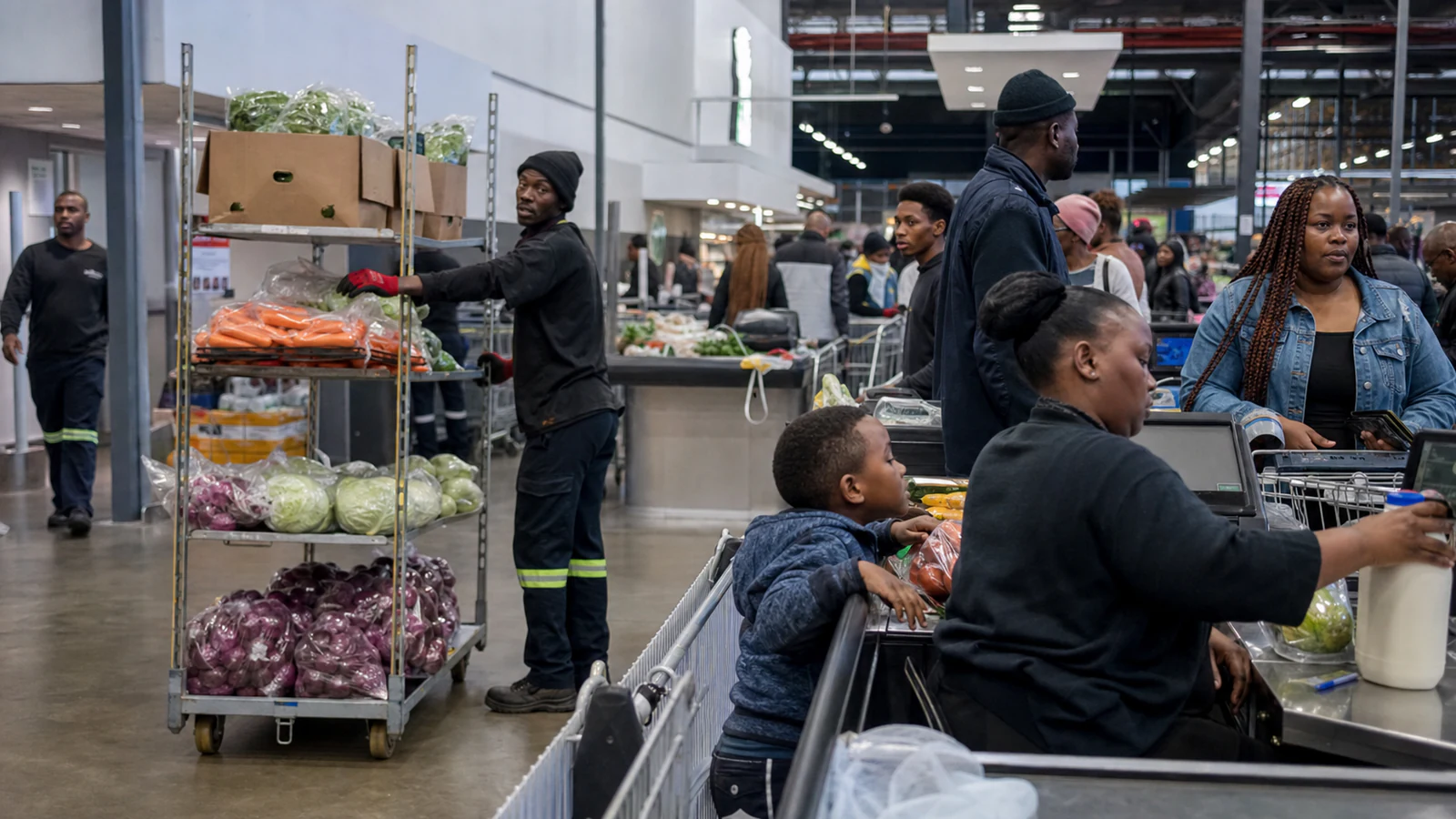 Shoppers and supermarket staff in a busy modern South African grocery store.